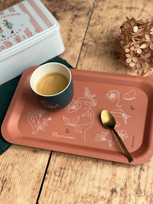 Plateau rectangulaire Fleurever en kraft recyclé avec motif floral et finition mate, accompagné d'une tasse à café et d'une cuillère dorée, sur fond en bois rustique